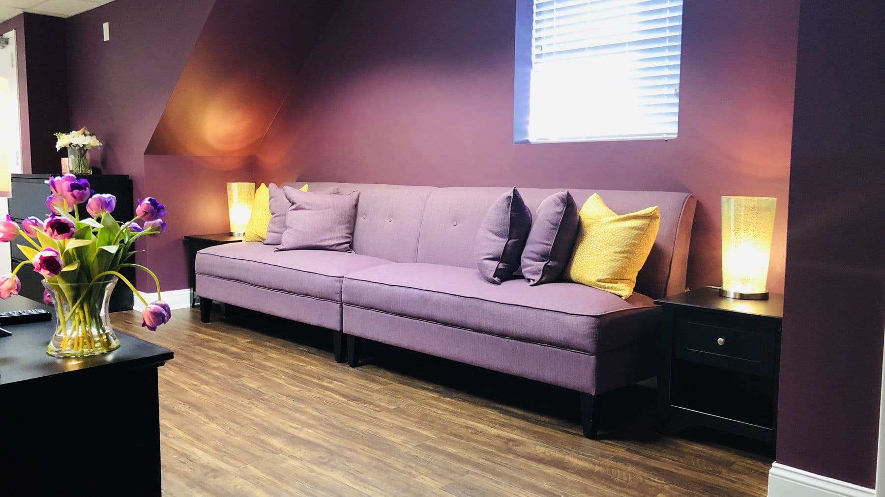The waiting room at our Springfield office: a lavender couch, warm lamps, and tulips